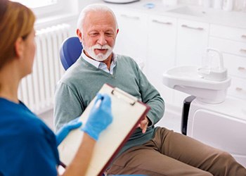 Dentist taking notes during patient consultation